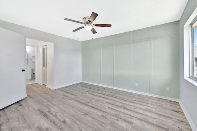 unfurnished room featuring ceiling fan, baseboards, and light wood-style floors