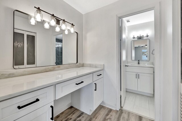 full bath featuring visible vents, vanity, and wood finished floors