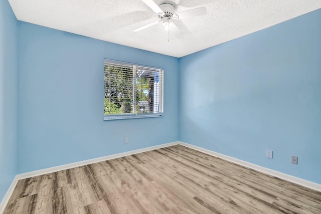 unfurnished room featuring a ceiling fan, wood finished floors, baseboards, and a textured ceiling