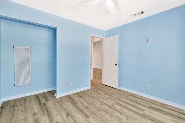 unfurnished bedroom featuring visible vents, baseboards, a closet, and wood finished floors