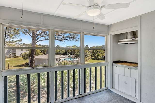 unfurnished sunroom featuring ceiling fan