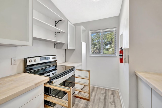 kitchen featuring double oven range, baseboards, open shelves, light wood-style flooring, and white cabinets