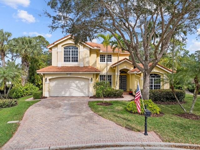 mediterranean / spanish-style house featuring a garage and a front lawn