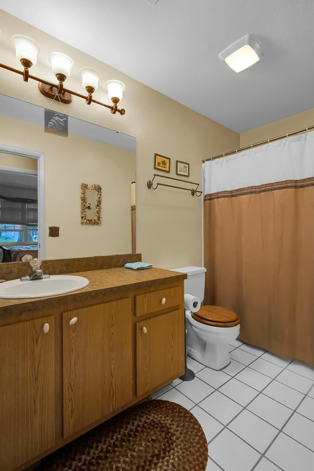 bathroom featuring tile patterned flooring, vanity, and toilet