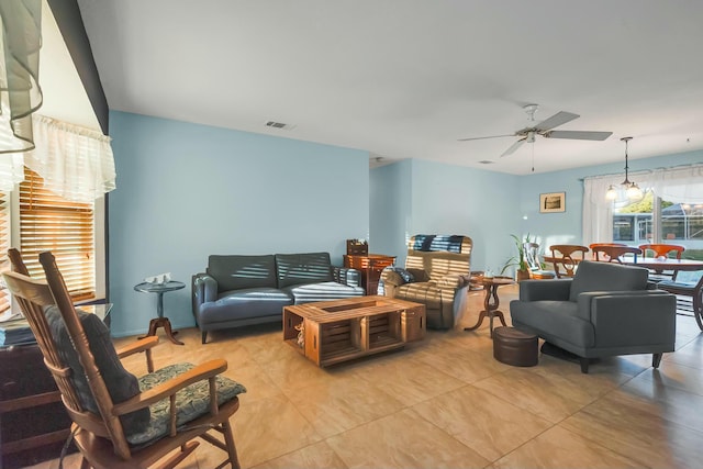 living room featuring ceiling fan with notable chandelier