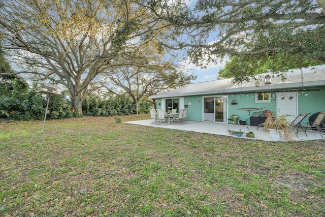 rear view of house with a yard and a patio area