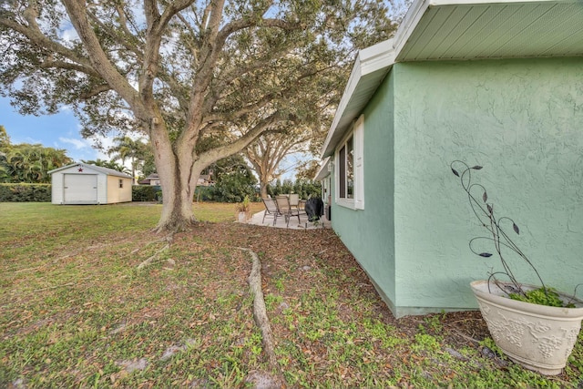 view of yard featuring a shed and a patio