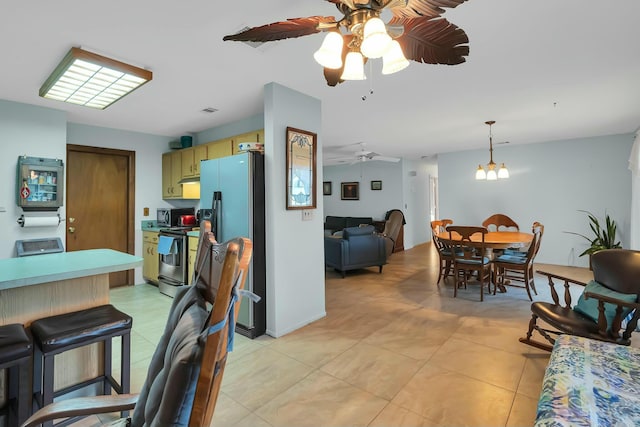 kitchen featuring green cabinetry, light tile patterned floors, appliances with stainless steel finishes, pendant lighting, and ceiling fan