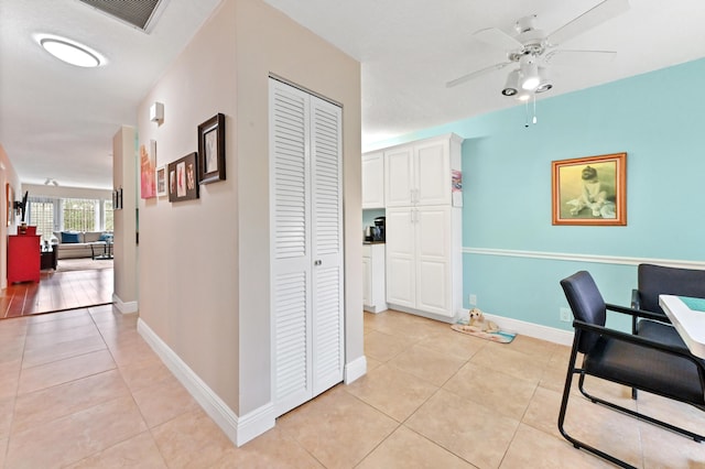 tiled home office featuring ceiling fan