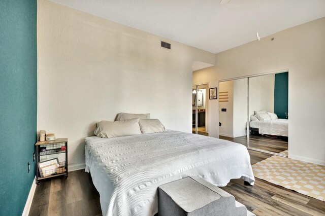 bedroom featuring a closet, visible vents, baseboards, and wood finished floors