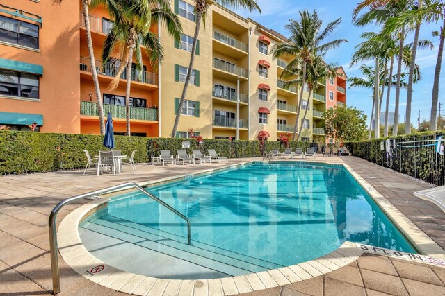 pool with a patio and fence