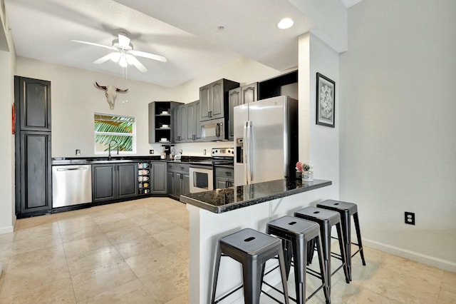 kitchen with open shelves, appliances with stainless steel finishes, a sink, a peninsula, and a kitchen bar