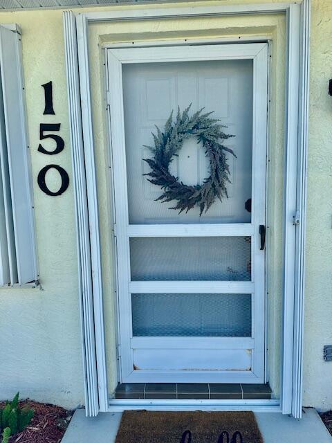 view of exterior entry with stucco siding