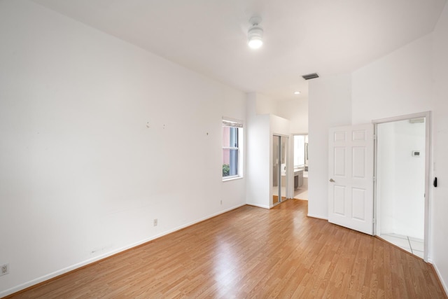 unfurnished room with light wood-style floors, baseboards, and visible vents