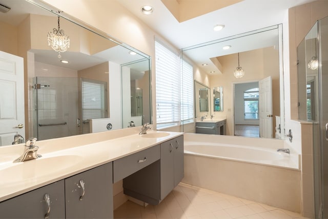 bathroom with a stall shower, a sink, and a notable chandelier