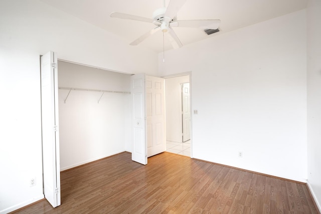 unfurnished bedroom featuring a closet, visible vents, ceiling fan, and light wood-style flooring