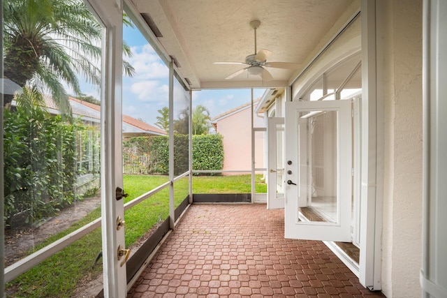 unfurnished sunroom featuring a ceiling fan