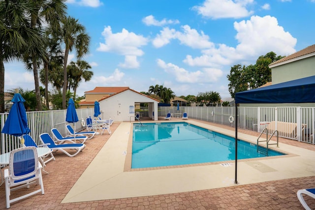 community pool featuring fence and a patio