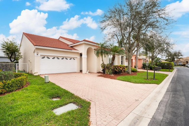 mediterranean / spanish home featuring a garage, a front lawn, decorative driveway, and stucco siding