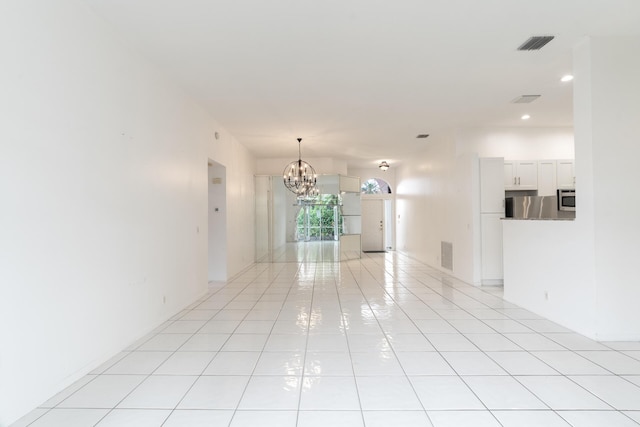 unfurnished room featuring visible vents, a notable chandelier, and light tile patterned floors