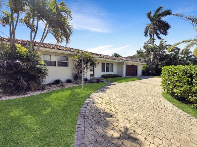 view of front facade with a front lawn, stucco siding, decorative driveway, and a garage