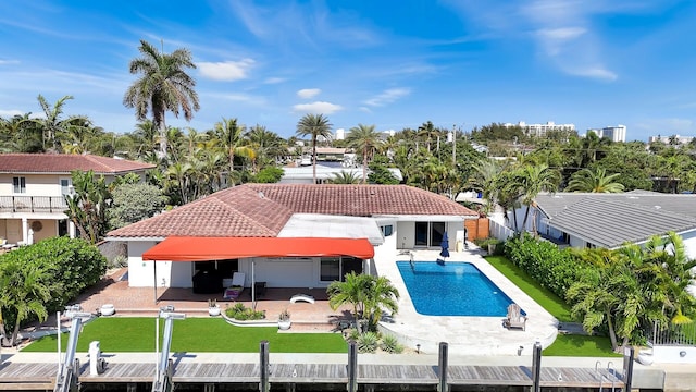 back of house with stucco siding, a patio area, fence, a tile roof, and a fenced in pool