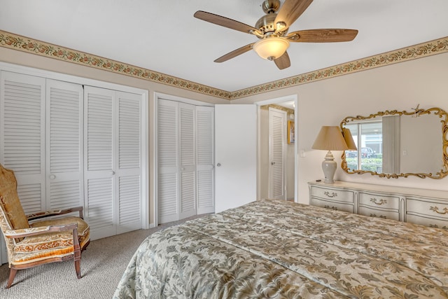 bedroom featuring carpet floors, two closets, and ceiling fan