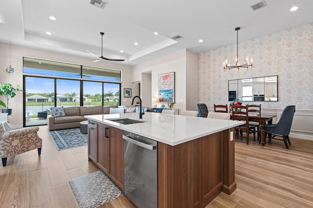 kitchen featuring pendant lighting, visible vents, stainless steel dishwasher, a kitchen island with sink, and wallpapered walls