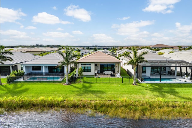 back of property with a lanai, a water view, an outdoor pool, and a yard