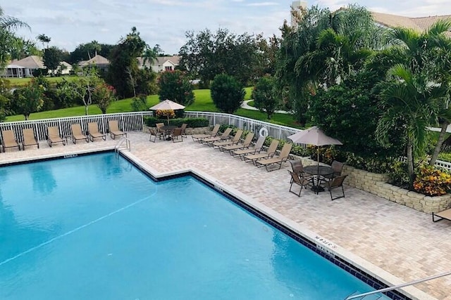 pool with a patio area and fence