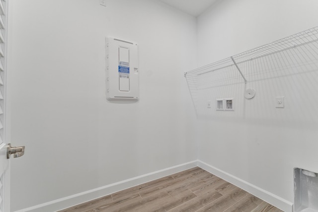 clothes washing area featuring gas dryer hookup, hardwood / wood-style flooring, electric dryer hookup, hookup for a washing machine, and electric panel