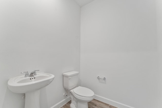 bathroom with hardwood / wood-style flooring, sink, and toilet