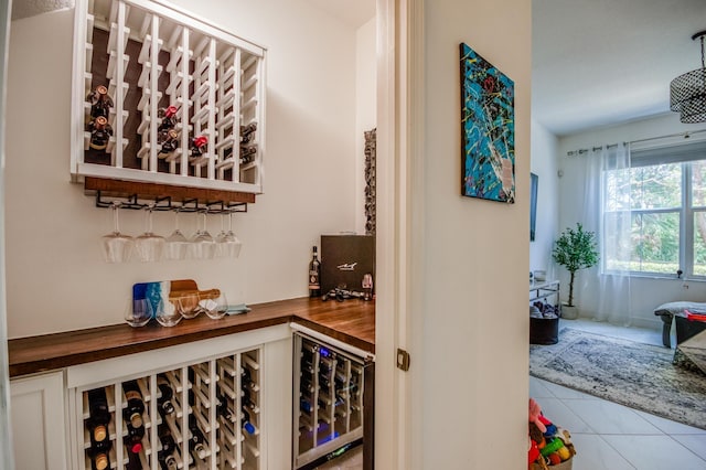 wine room with tile patterned flooring, wine cooler, and indoor bar