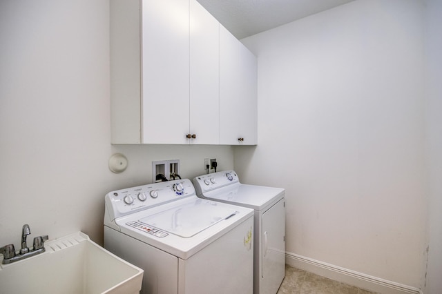 washroom with sink, washer and clothes dryer, and cabinets