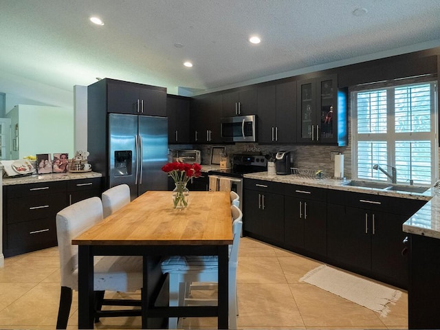 kitchen with sink, backsplash, stainless steel appliances, and light tile patterned flooring