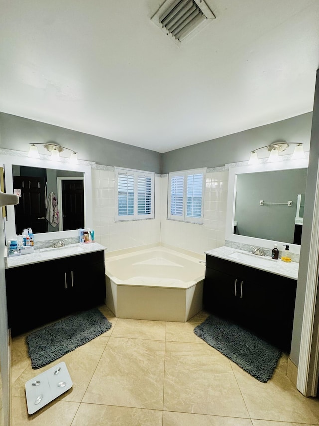 bathroom featuring tile patterned flooring, vanity, and a bath