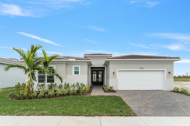 view of front of house featuring a garage, a front yard, and french doors