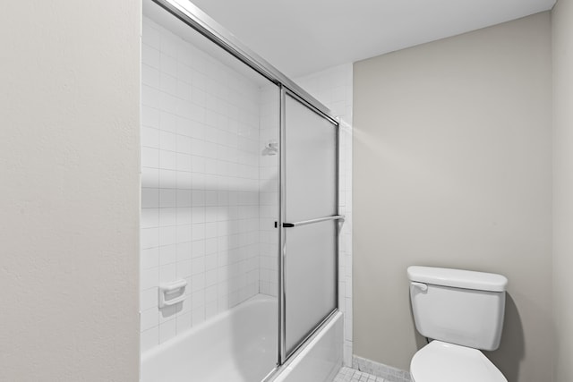 bathroom with tile patterned flooring, enclosed tub / shower combo, and toilet