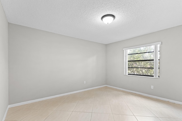 empty room featuring light tile patterned floors and a textured ceiling