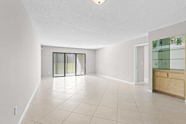 tiled empty room with a textured ceiling