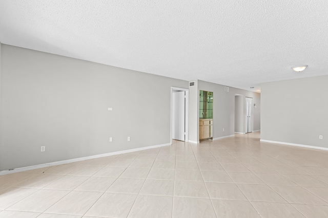 empty room with light tile patterned floors and a textured ceiling