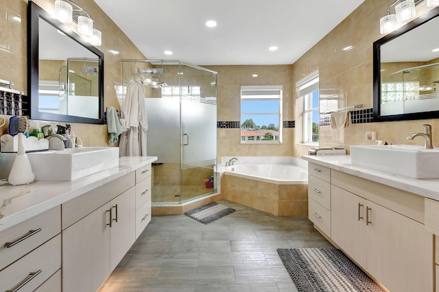 bathroom featuring tile walls, vanity, and separate shower and tub