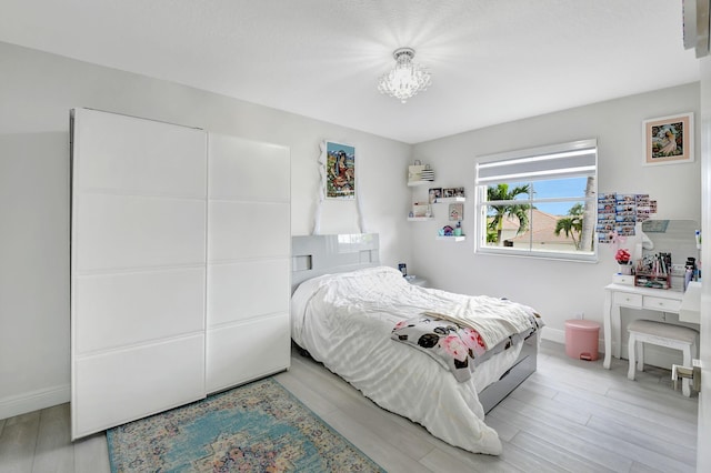 bedroom featuring hardwood / wood-style flooring and an inviting chandelier