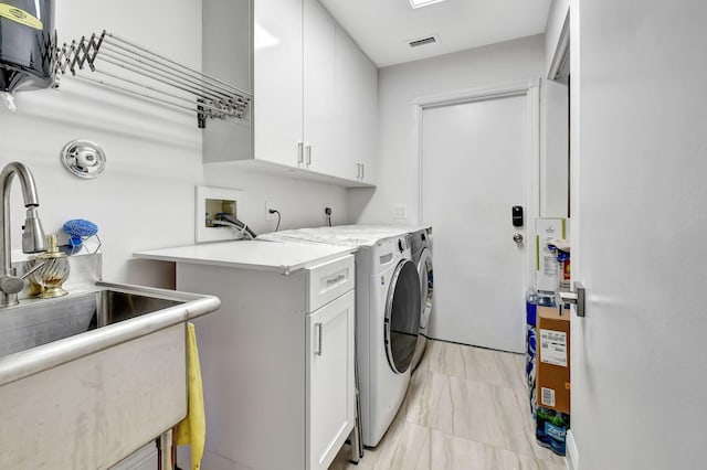 washroom with sink, cabinets, and washing machine and clothes dryer