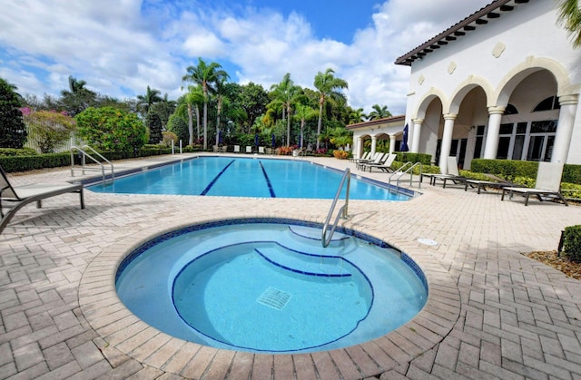 view of pool featuring a hot tub and a patio area