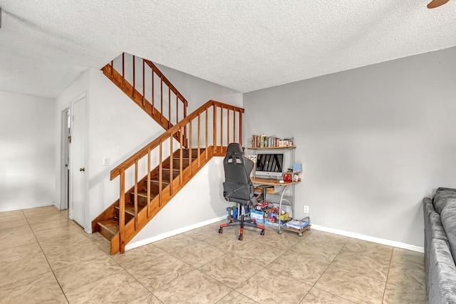 home office with a textured ceiling, tile patterned flooring, and baseboards