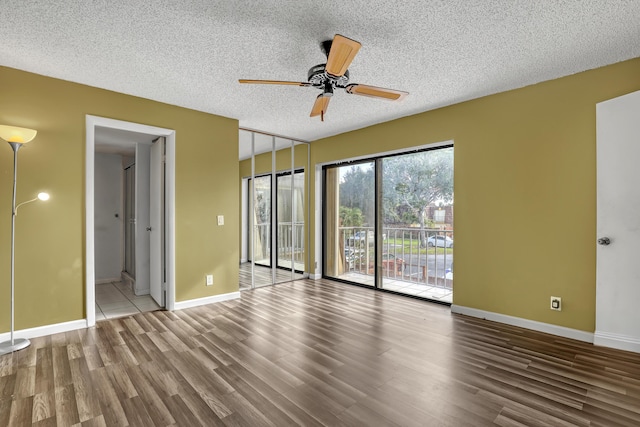 unfurnished bedroom with access to exterior, a ceiling fan, a textured ceiling, wood finished floors, and baseboards