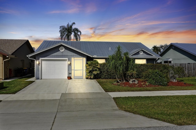 ranch-style house featuring a yard and a garage