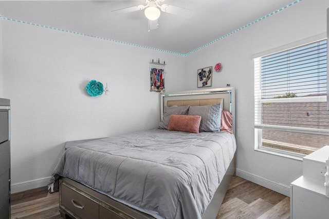 bedroom featuring wood finished floors, baseboards, and ceiling fan