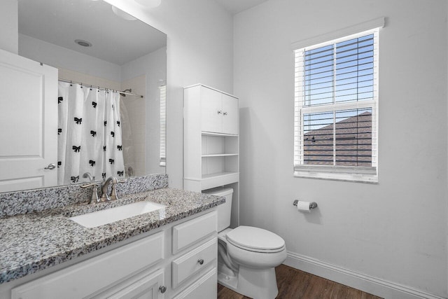 bathroom with vanity, a shower with shower curtain, wood finished floors, baseboards, and toilet